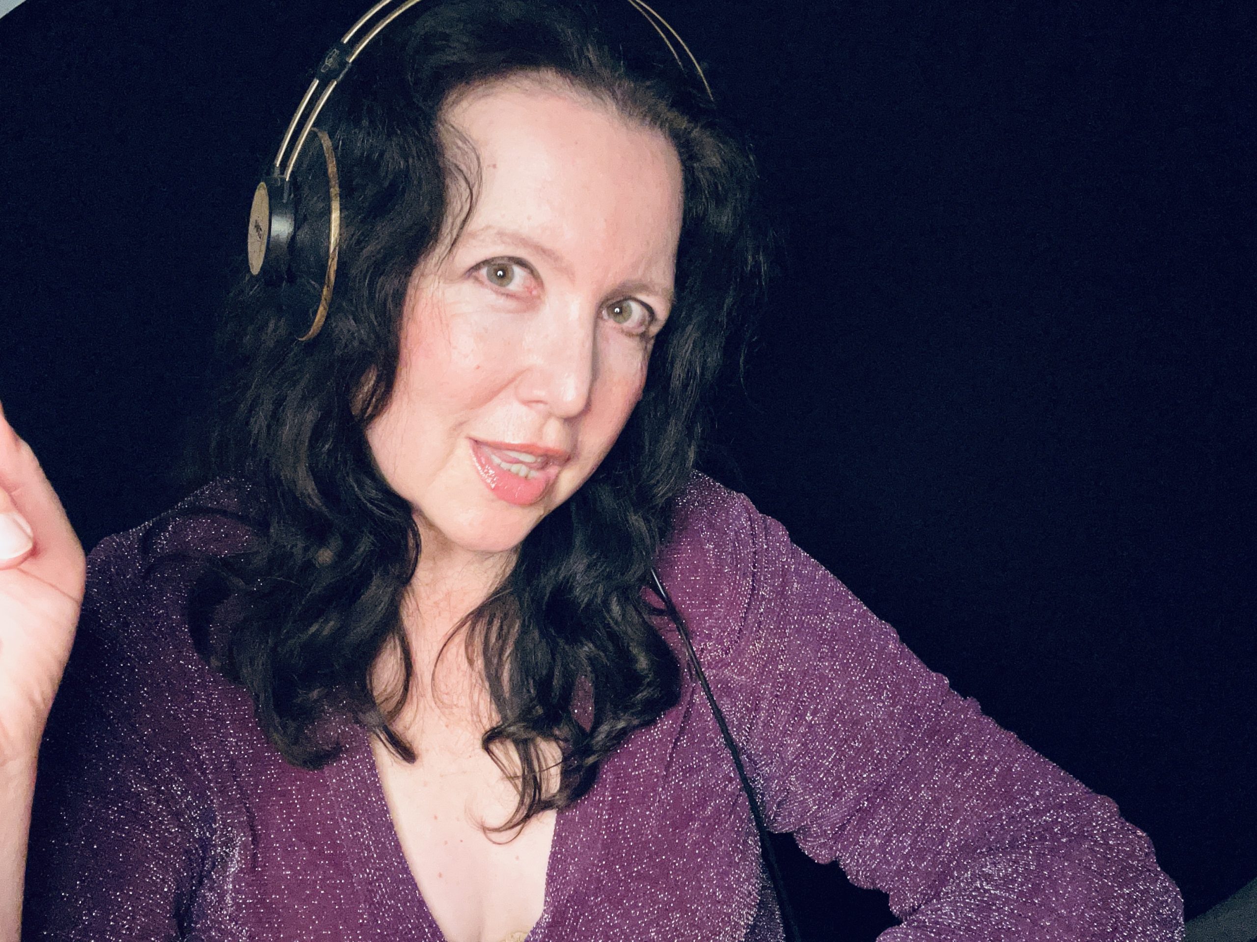 Anne-Lise wearing a sparkly plum dress and headphones.